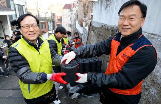 김용환 NH농협금융지주 회장(왼쪽)과 이경근 서울지방보훈청장이 11일 임직원들과 함께 서울 은평구 소재 6·25 참전유공자 보훈가정에 사랑의 연탄나눔 사회공헌활동을 펼치고 있다.  NH농협금융지주 제공